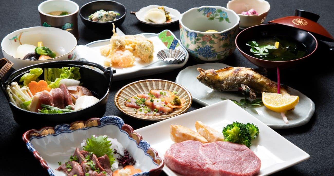 Ryokan Hitaya with a Japanese dinner arranged across black and white tableware.