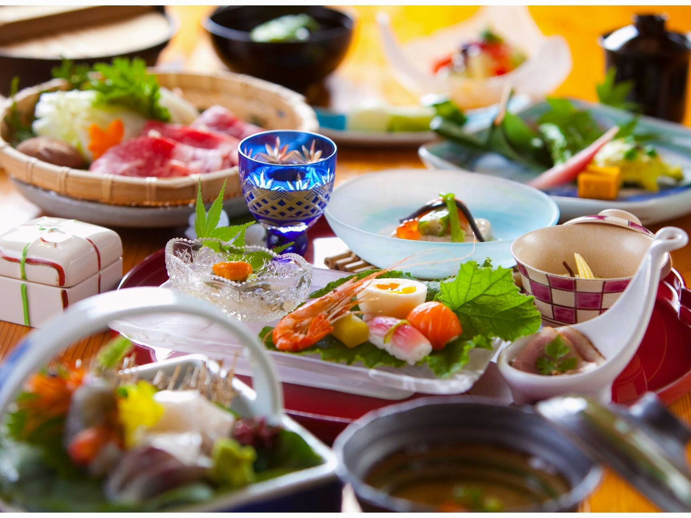 Oyado Yuraku with a colorful Japanese dinner arranged across patterned ceramics.