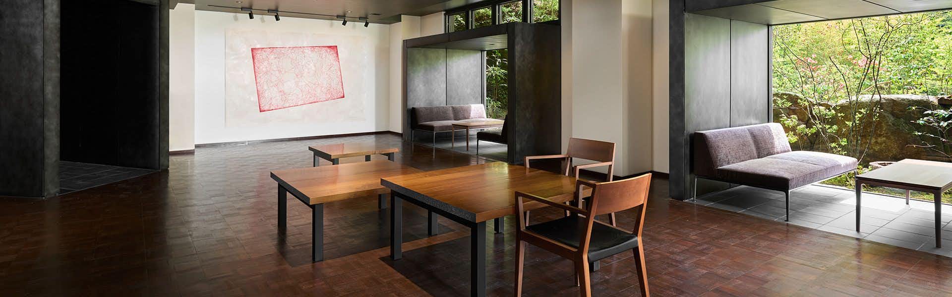 Kyoto Yunohana Onsen Sumiya Kiho-an with a contemporary sitting room with pale sofa and garden terrace.