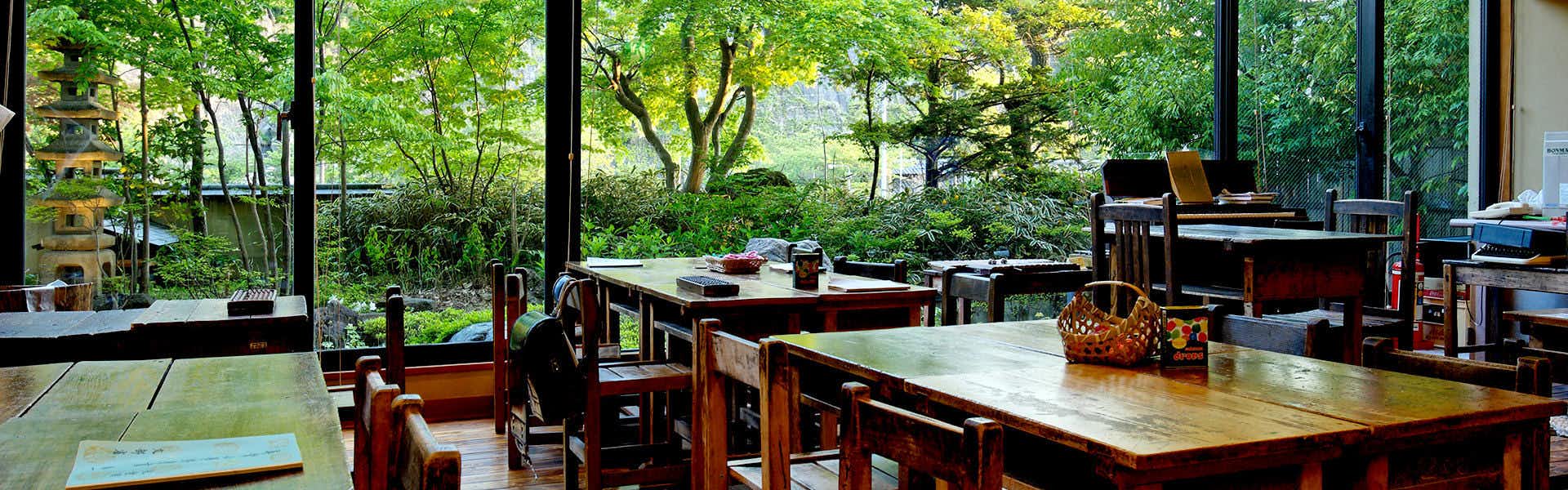 Shibu Onsen Shibu Hotel with a bright dining room surrounded by leafy garden windows.