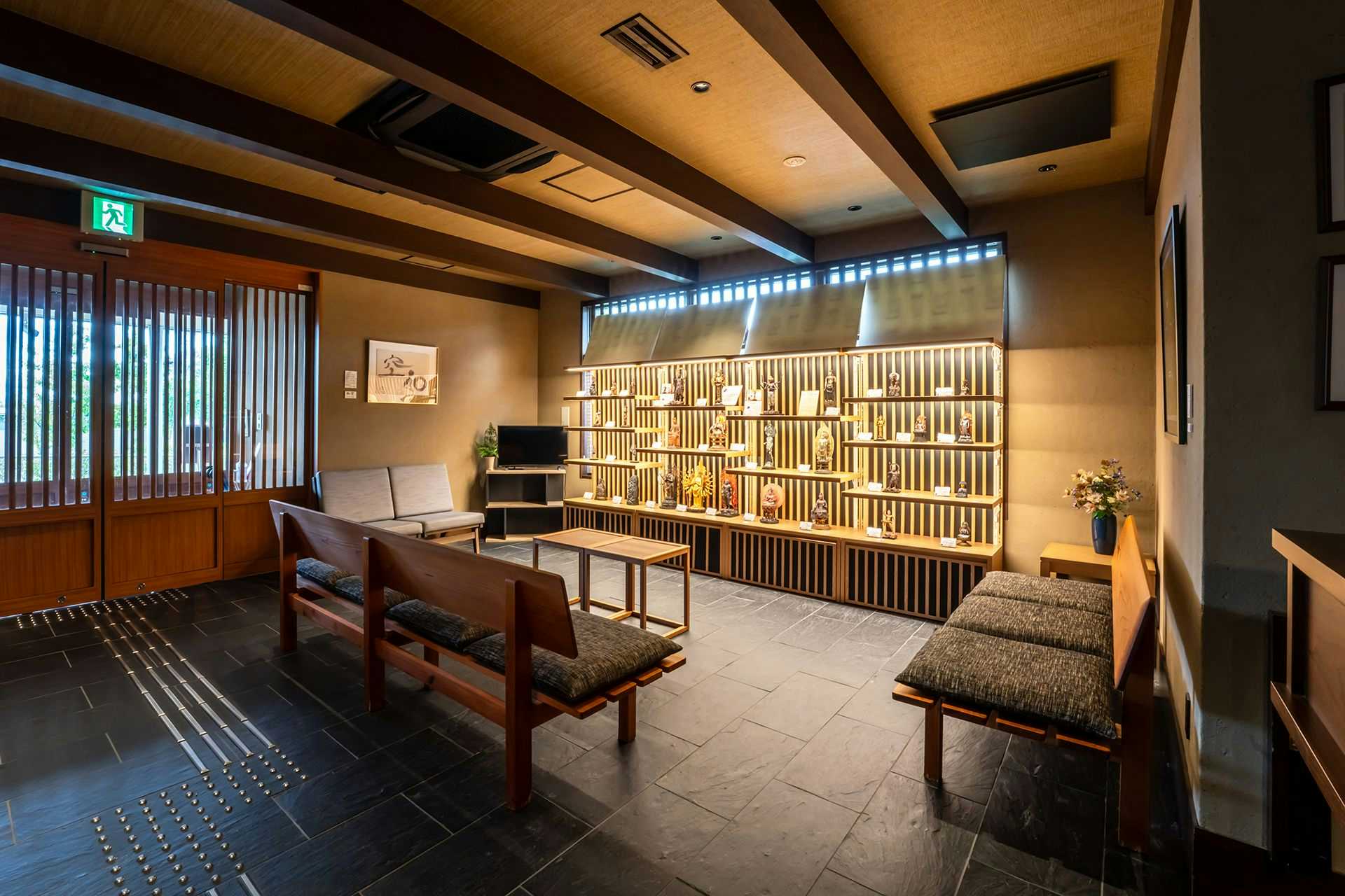 Waqoo Horyuji with a refined lobby with timber display shelves and dark tiled floors.