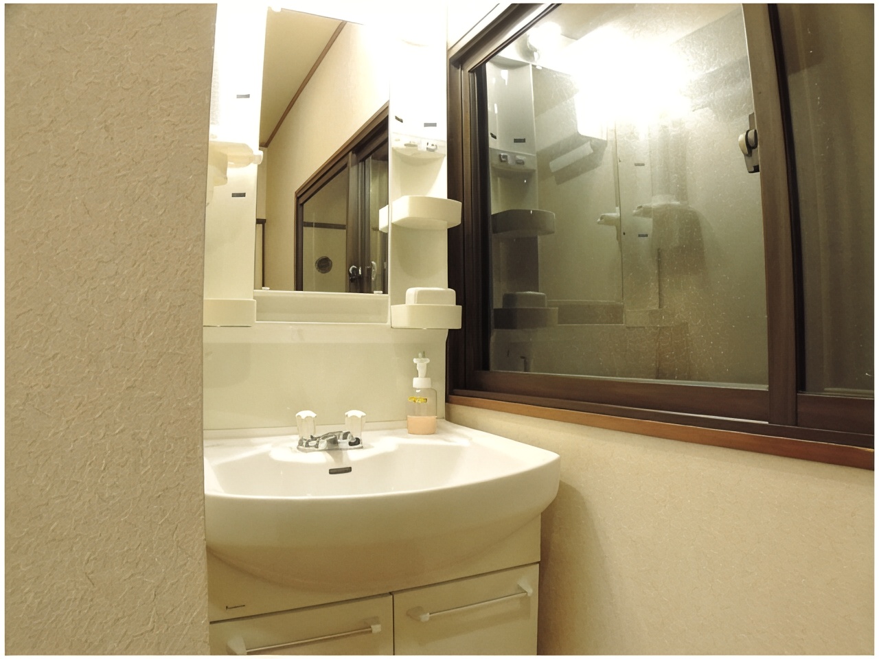 A washroom with a sink, mirror, and frosted window.