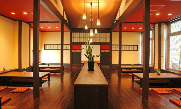 A warmly lit dining room with low tables.