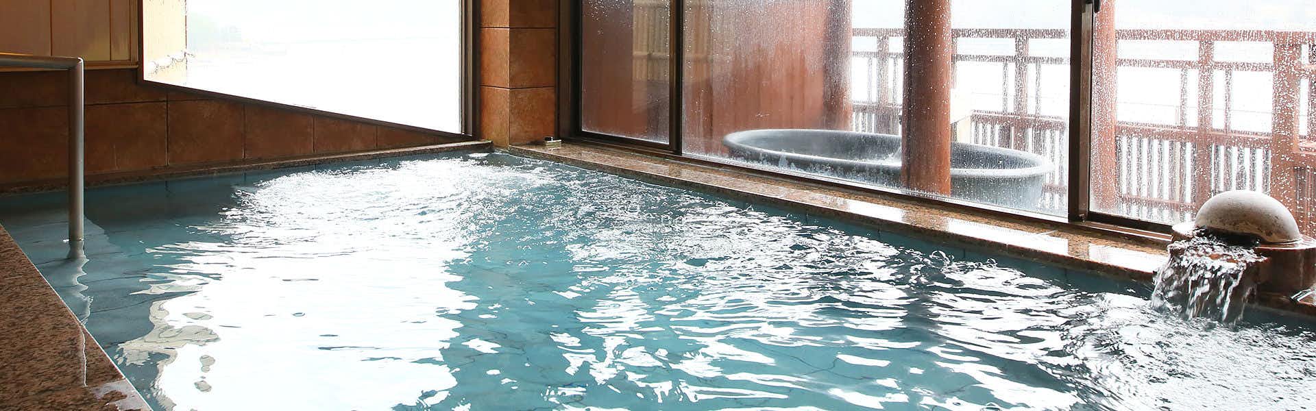 Hana Mizutei Ooya with a bright indoor mineral bath with timber trim.