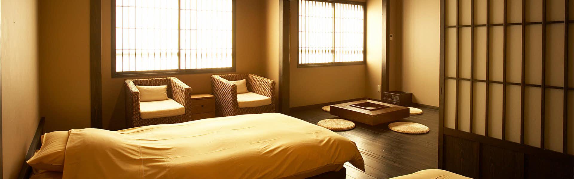 Echigo Yuzawa HATAGO Isen with a restful bedroom with low bed and window seating.