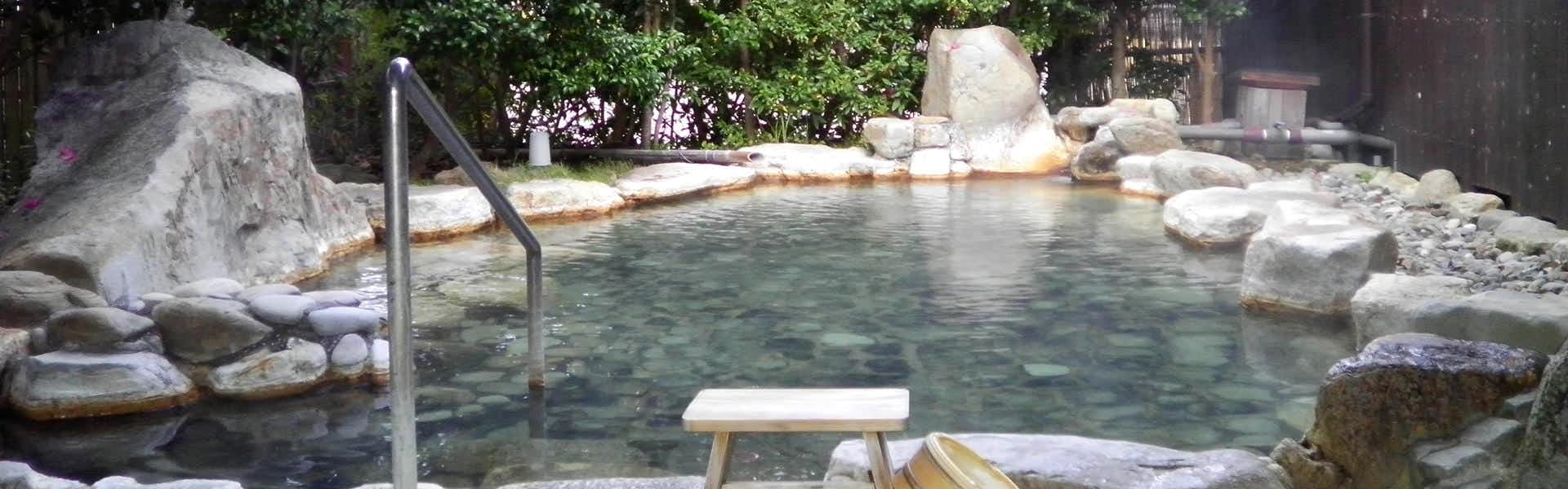 Hotel Yamayuri at Watarase Onsen, Dairoten no Yado with a wide open-air rock bath beneath leafy trees.