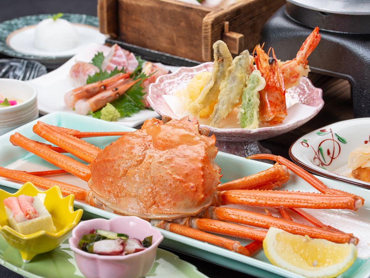 Kani to Katsugyo Ryori no Yado Kaifutei Teradomari Nihonkai with a whole crab served beside soup and ceramic bowls.