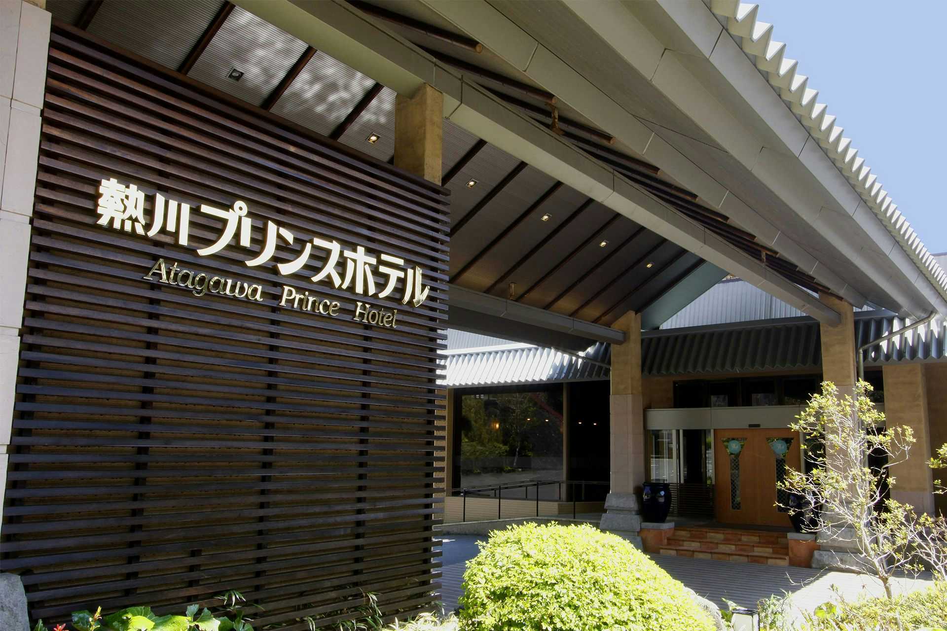 Atagawa Prince Hotel with the modern hotel entrance beneath a white canopy and palm trees.
