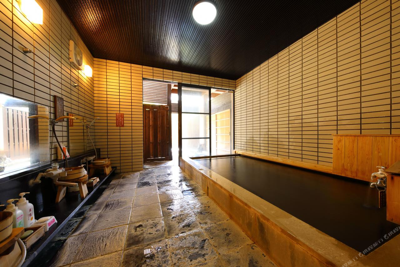 A long indoor bath is framed by warm wood and glass.