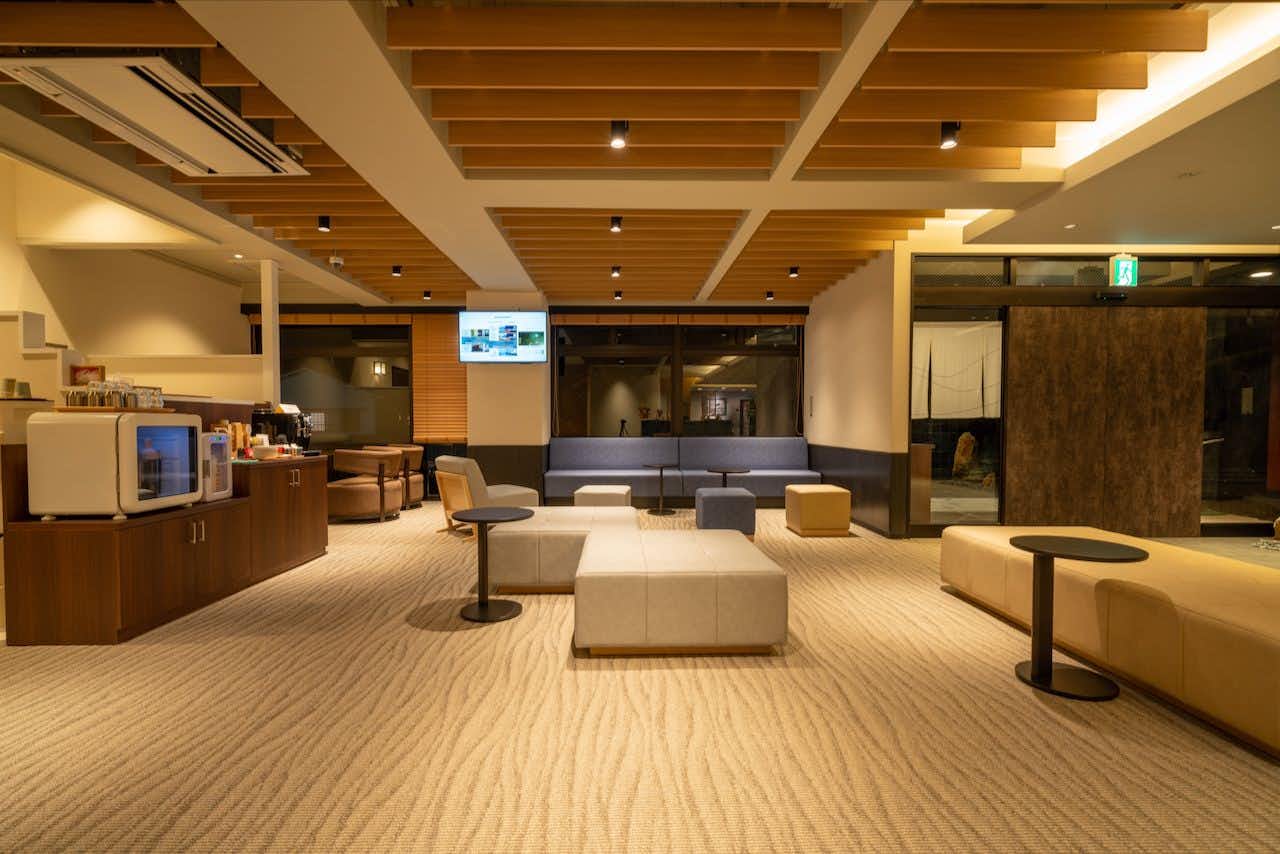 Taste and Hot Spring Inn New Tomiyoshi with a modern lobby furnished with low cream sofas.