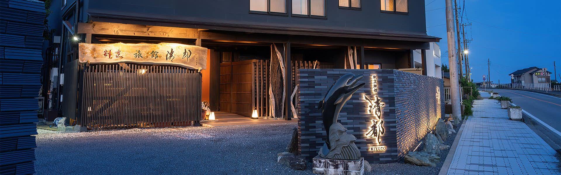 Kappo Ryokan Kiyoto illuminated exterior entrance beneath a tiled roof at dusk