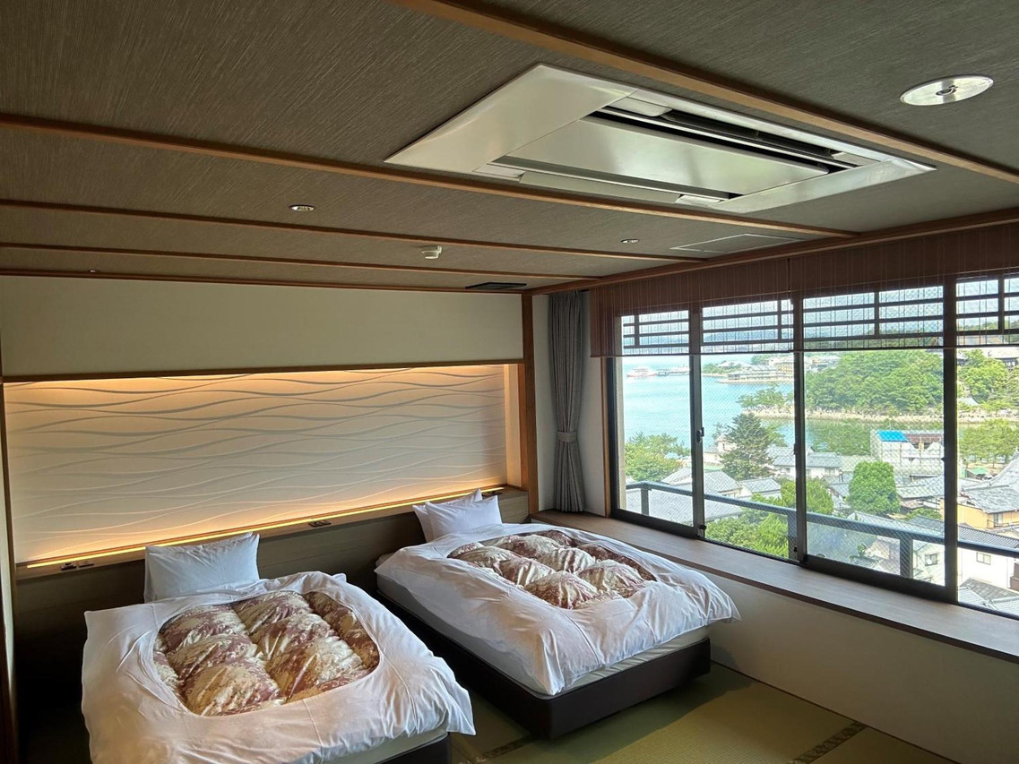 Guest room with beds and a wide window.