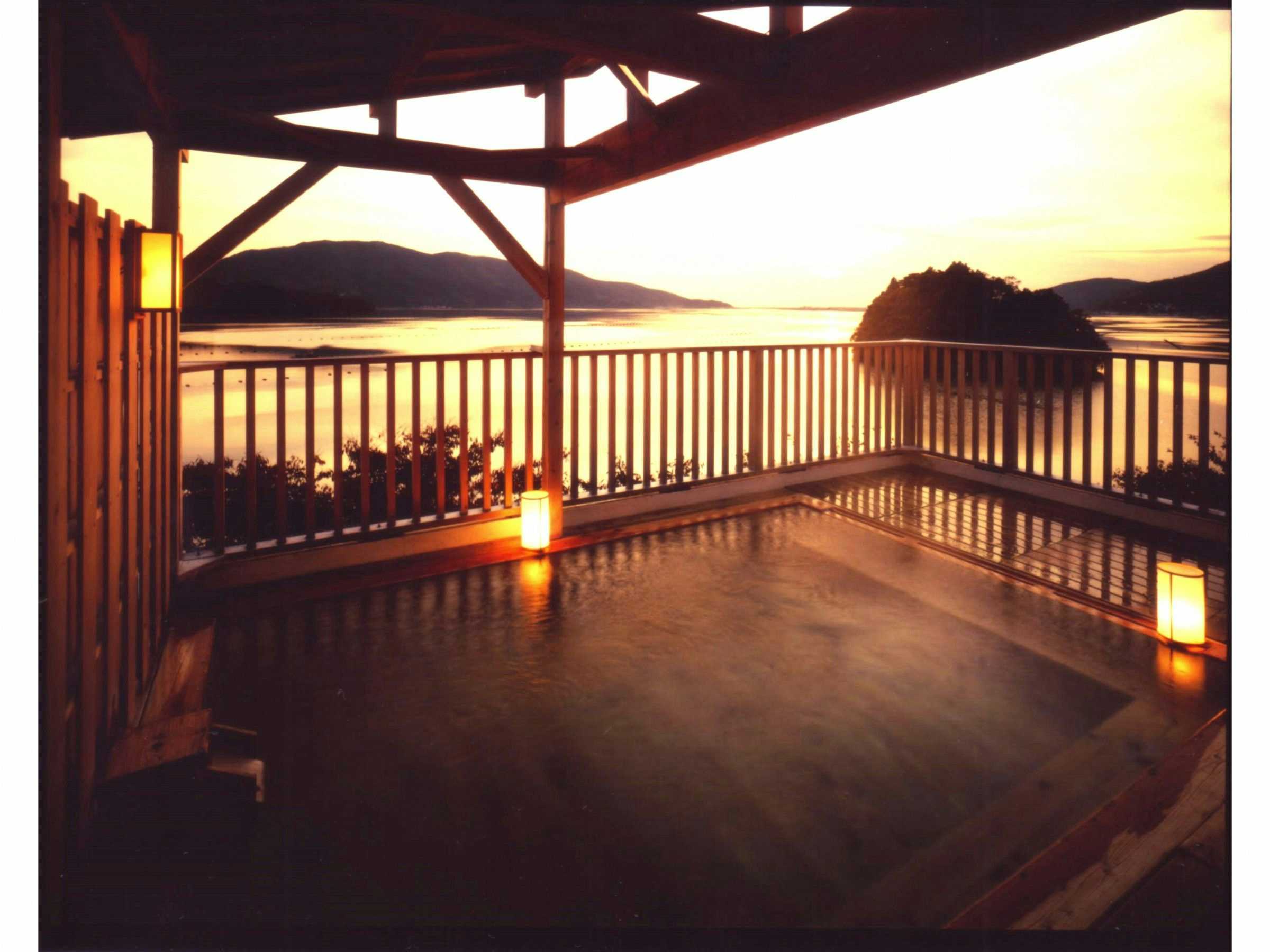 Onagawa Onsen Hanayubi with a sunset terrace overlooking the bay through timber railings.