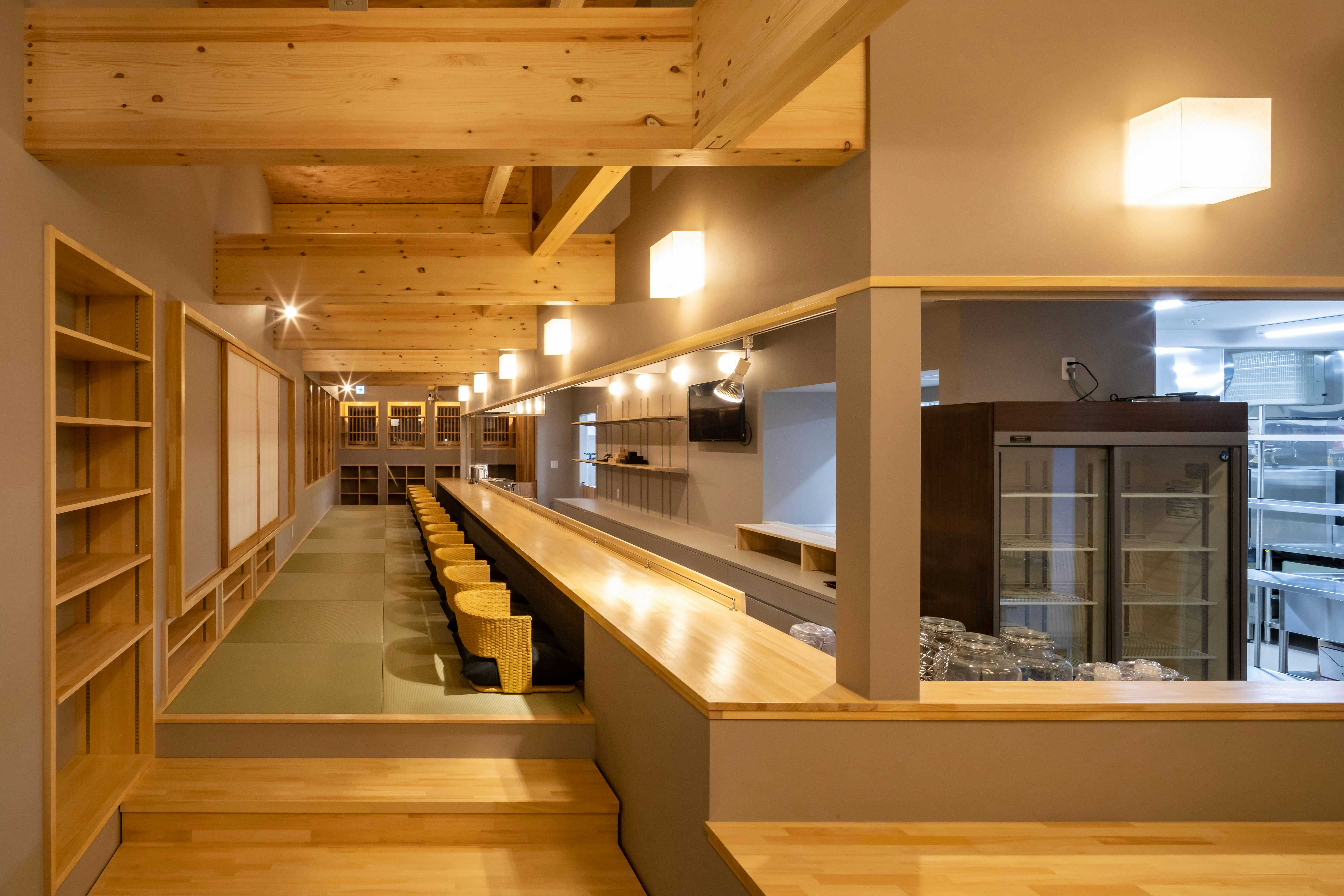 Tazawako Kogen Mizusawa Onsenkyo Ryokan Aoniyama-so with a long timber counter beneath exposed wooden ceiling beams.