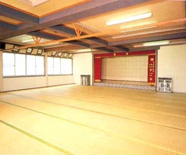 A large tatami hall beneath exposed wooden beams.
