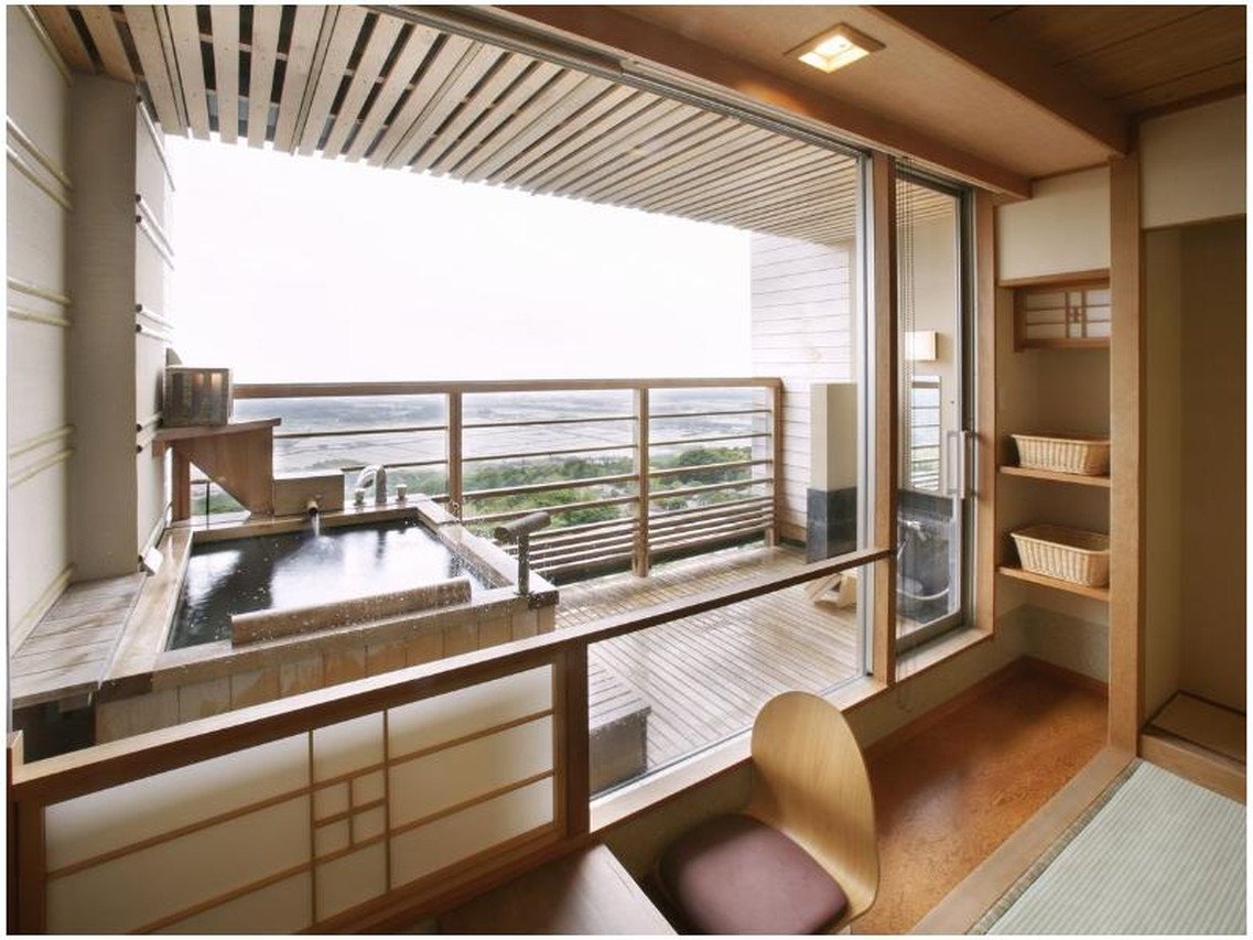 Balcony soaking tub above a distant landscape.