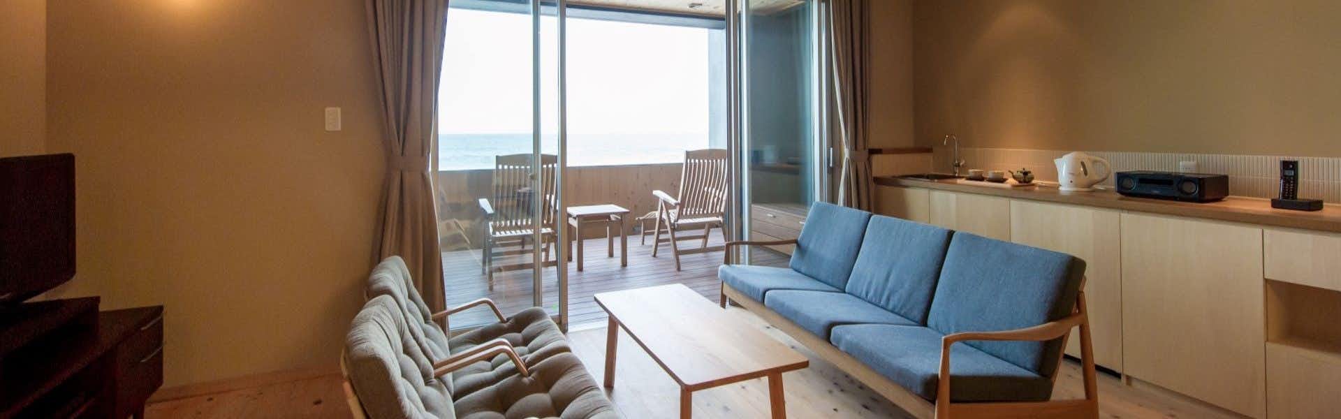 Satoumitei Kinparo Main Residence with a serene lounge with pale blue sofa and ocean windows.