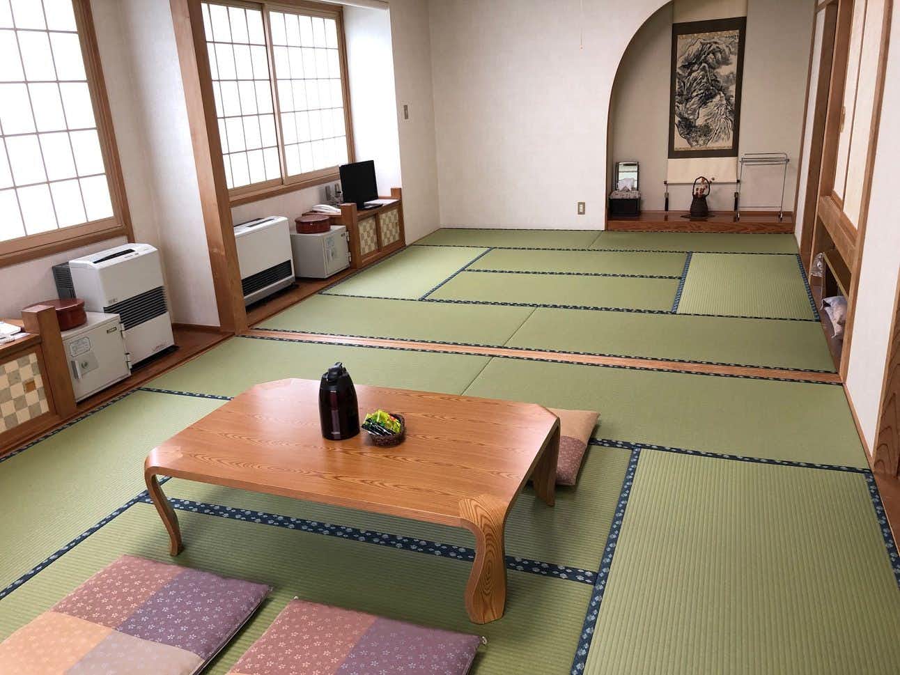 Gassan Inn Kashiwaya with a spacious tatami room with low table and mountain-facing windows.