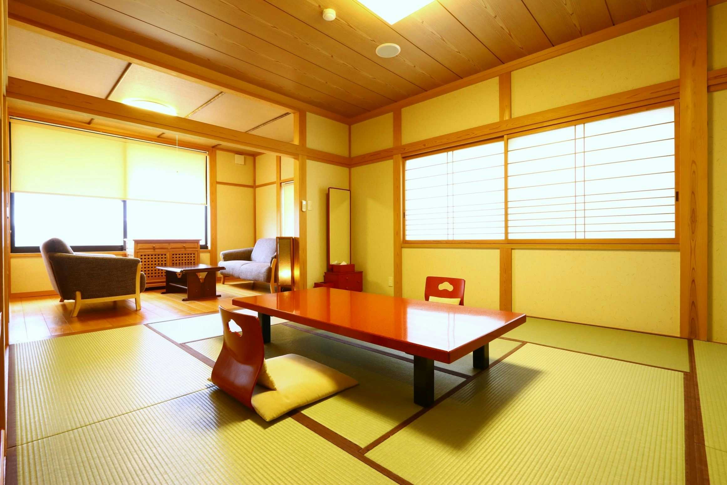 Kami-no-Miya Onsen Kawaratei tatami room with a red low table and adjoining armchairs