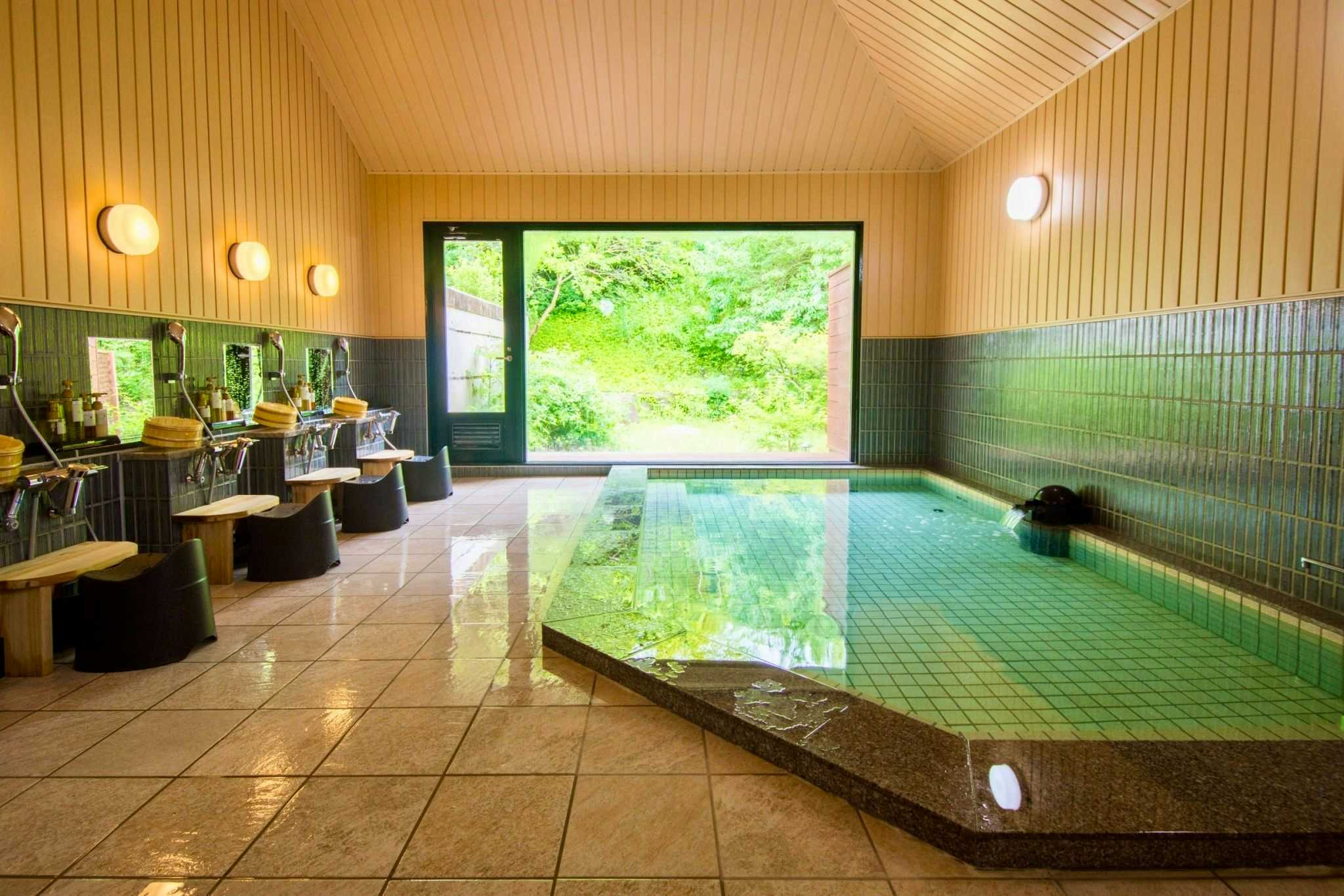 Onyado Hanawarabi with an indoor mineral bath facing a leafy green garden.