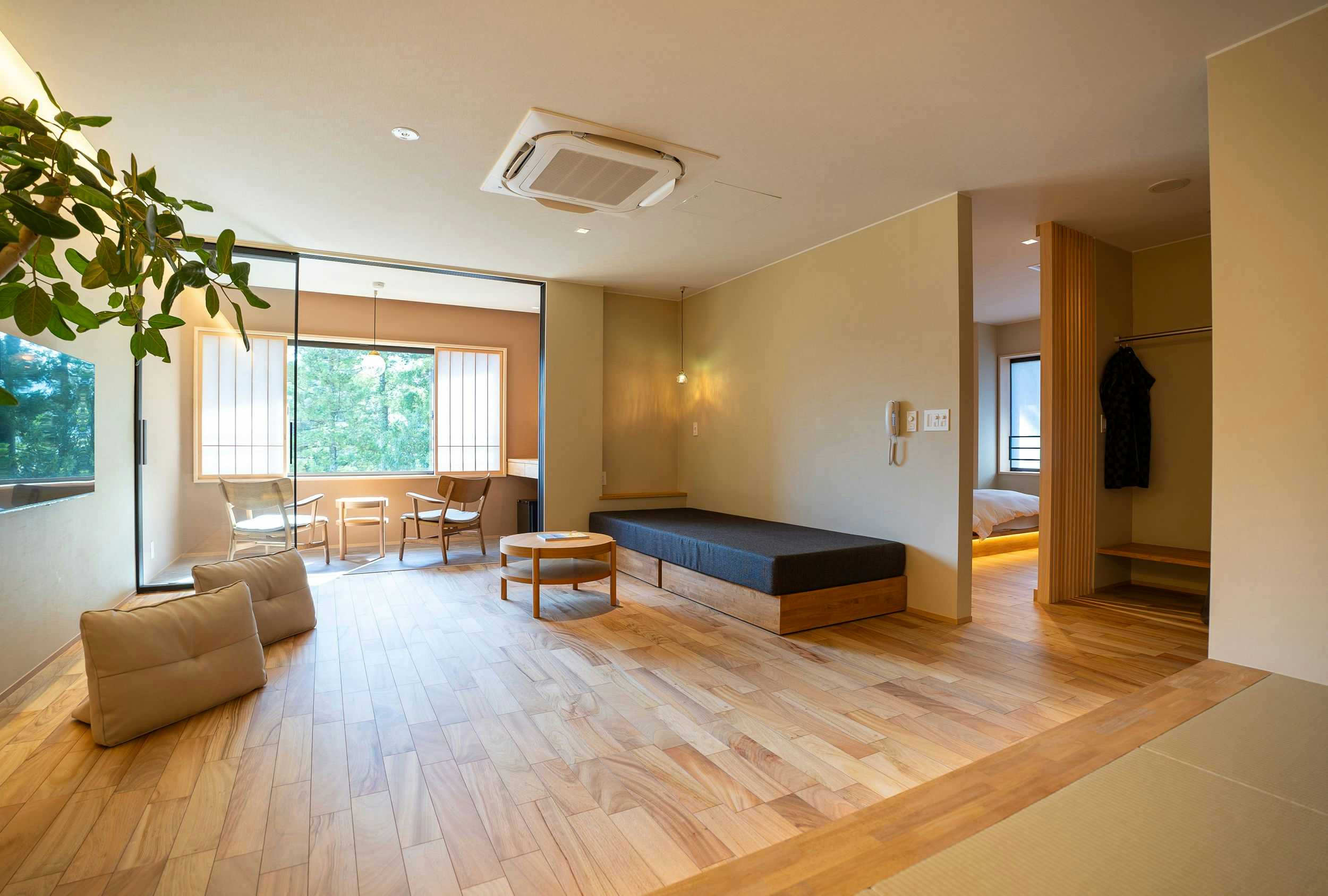 Gyokusenkaku with a bright contemporary lounge with pale timber floors.