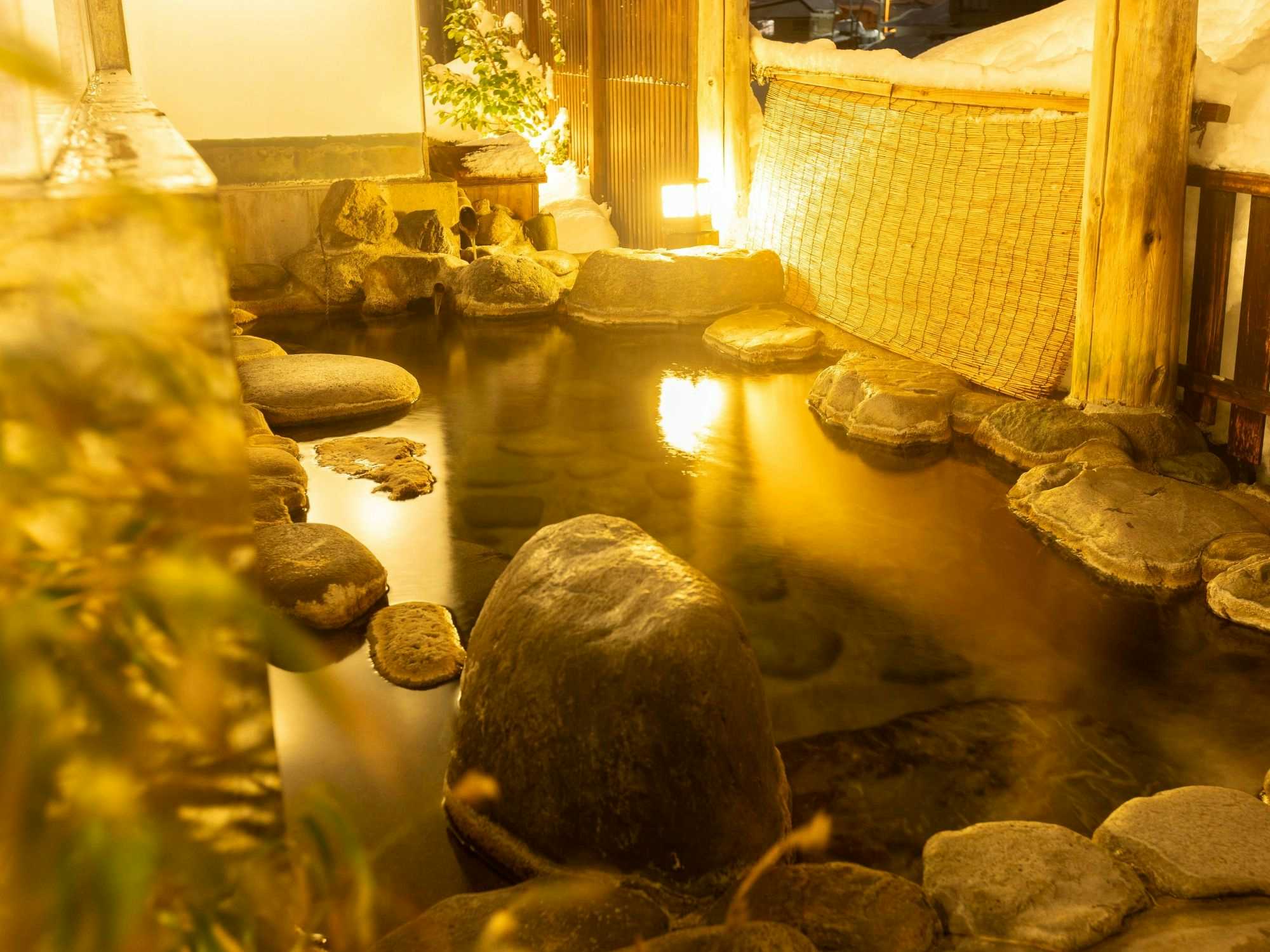 Warabe Uta no Yado Yunohara with this scene, where its steaming rock-lined bath is enclosed by timber walls.