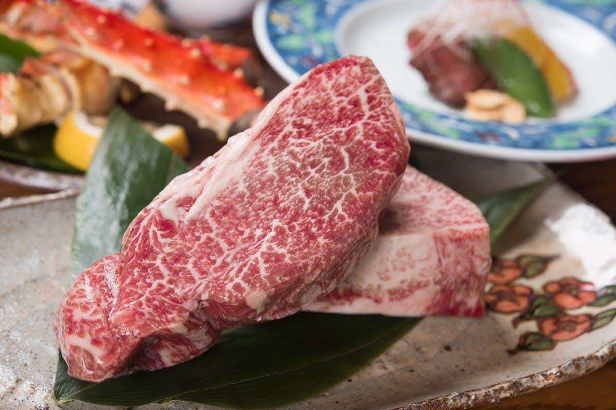 Seasonal Cuisine and Hot Springs Inn Tokiwaso with thick marbled beef presented on a green leaf.
