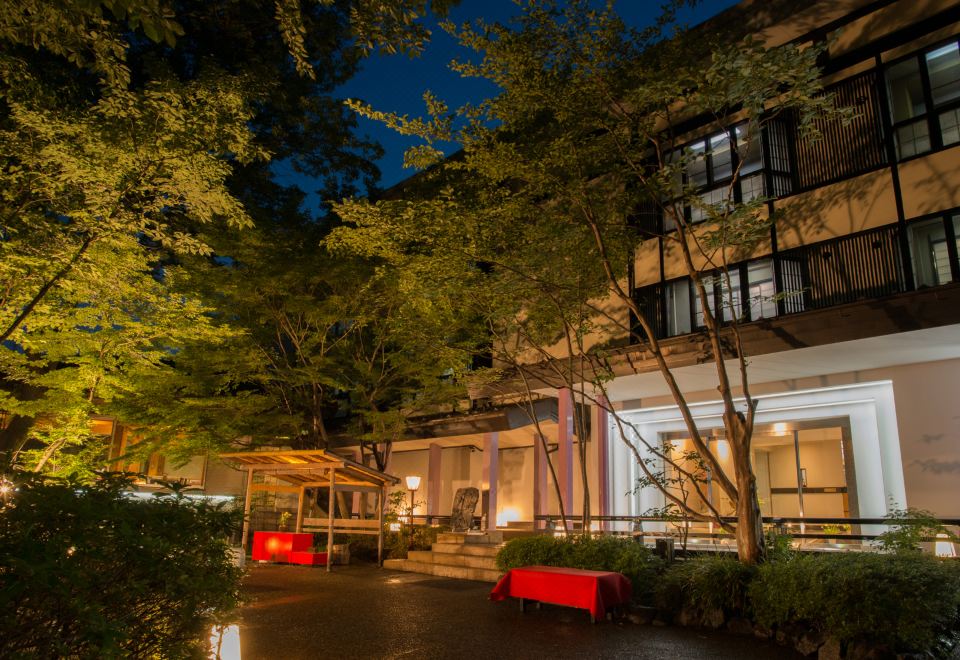 A ryokan building glows among trees at night.
