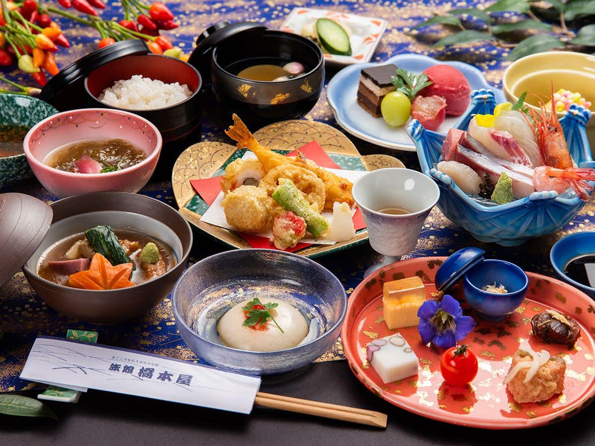 Ryokan Hashimotoya with an elaborate Japanese dinner arranged across colorful small plates.