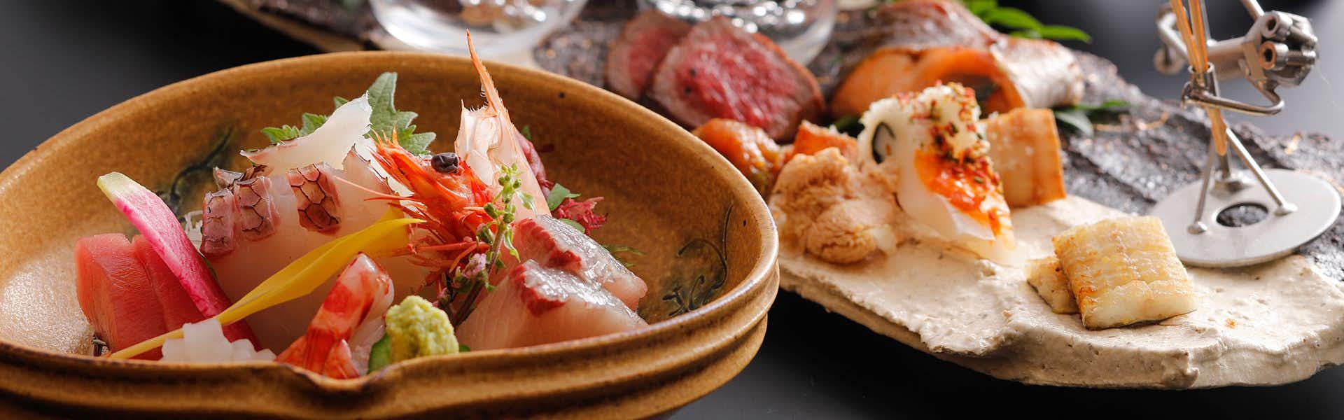 Kariya Ryokan Q with this scene, where sashimi and colorful vegetables are arranged in a shallow ceramic bowl.