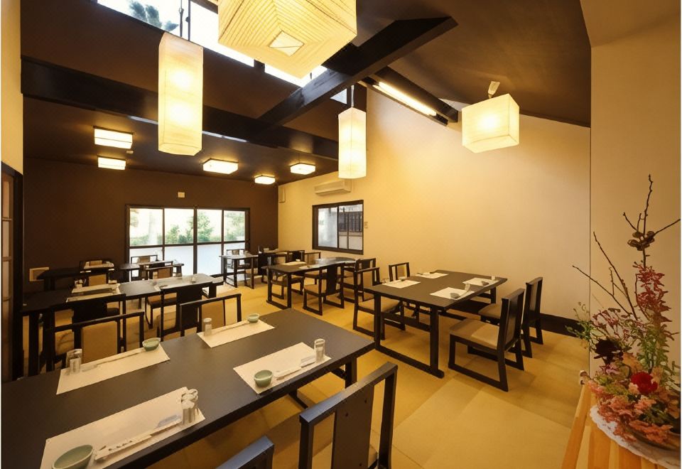 A dining room with tables set beneath hanging lanterns.