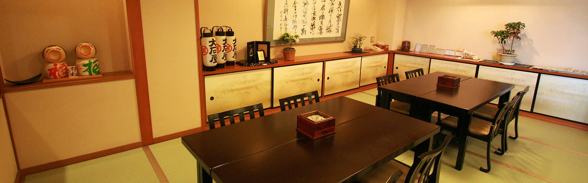 Soshin no Yado Oishiya tatami dining room with dark tables, chairs and decorated wall shelves