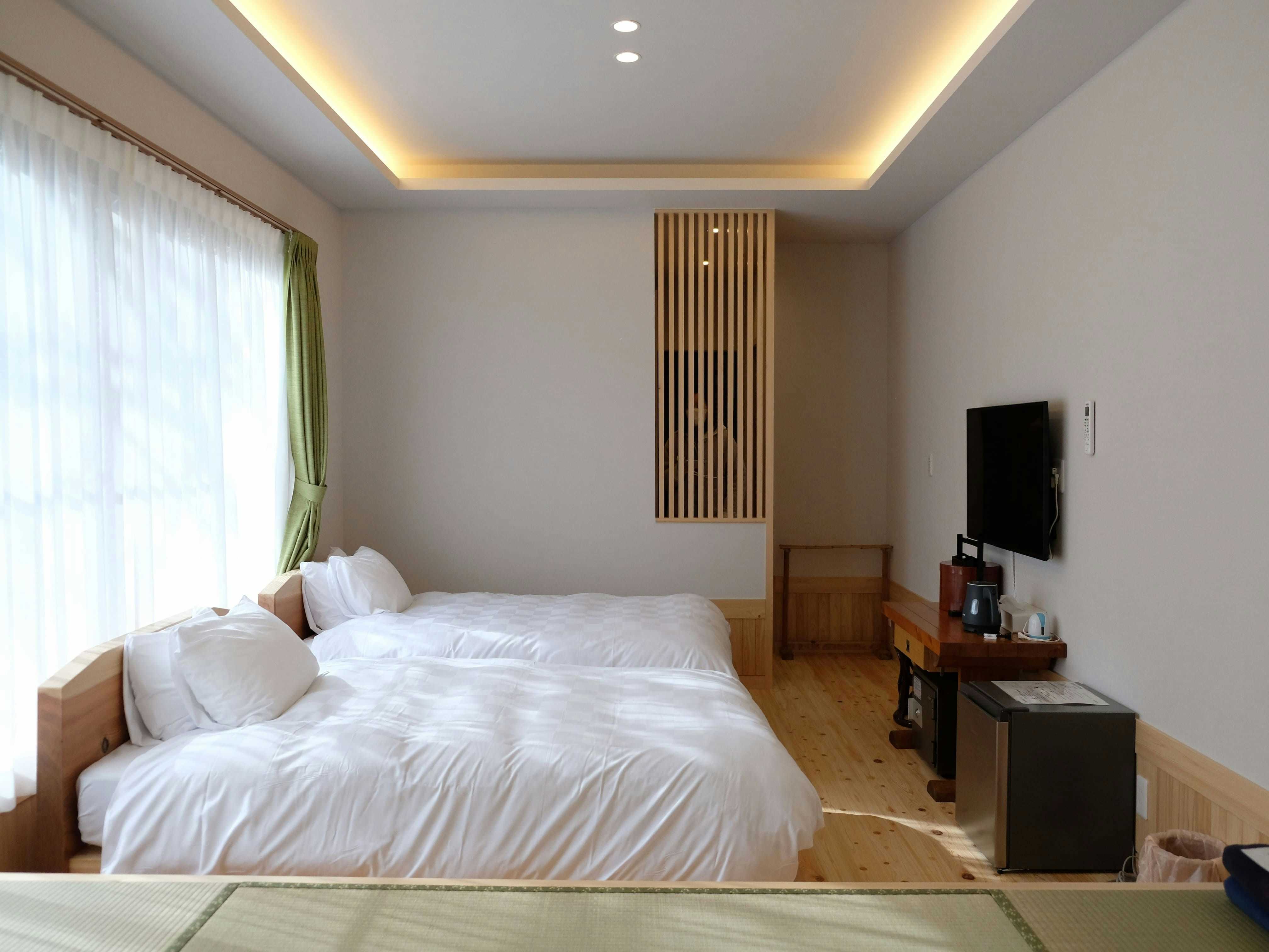 Hiogiso with a bright modern bedroom with white bedding and pale timber accents.