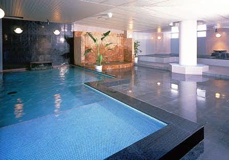Amakusa Shimoda Onsen Boyokaku with a blue-tiled indoor pool bath beneath a timber ceiling.