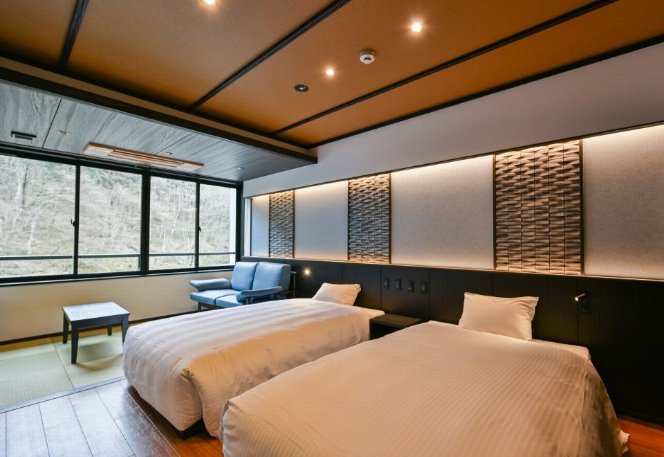 A modern twin room with large windows.