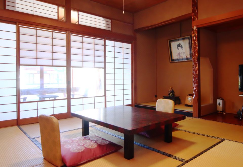 A tatami room with a low table and wall scroll.