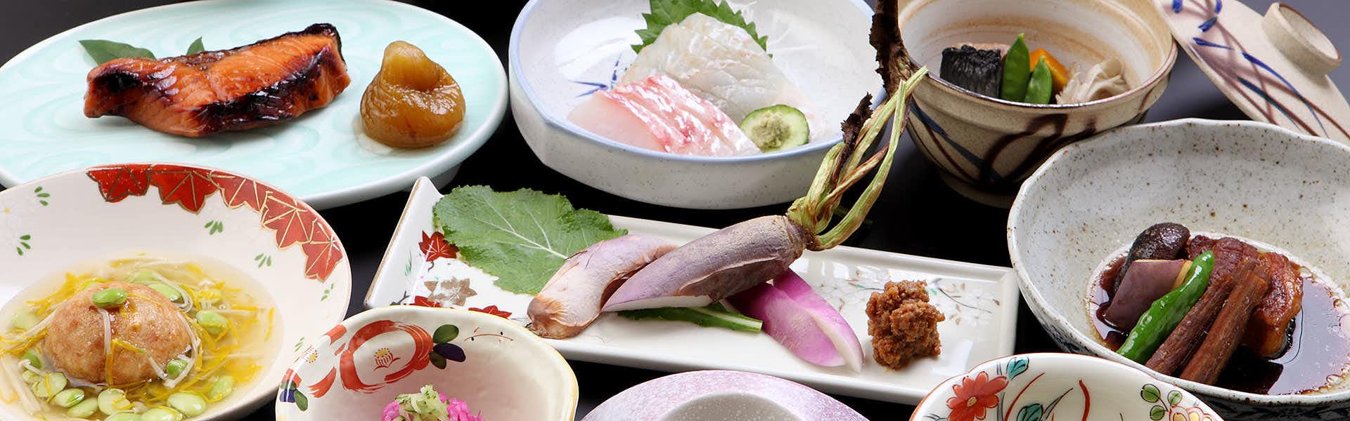 Tsukasaya Ryokan with a multi-course dinner featuring grilled fish and sashimi.