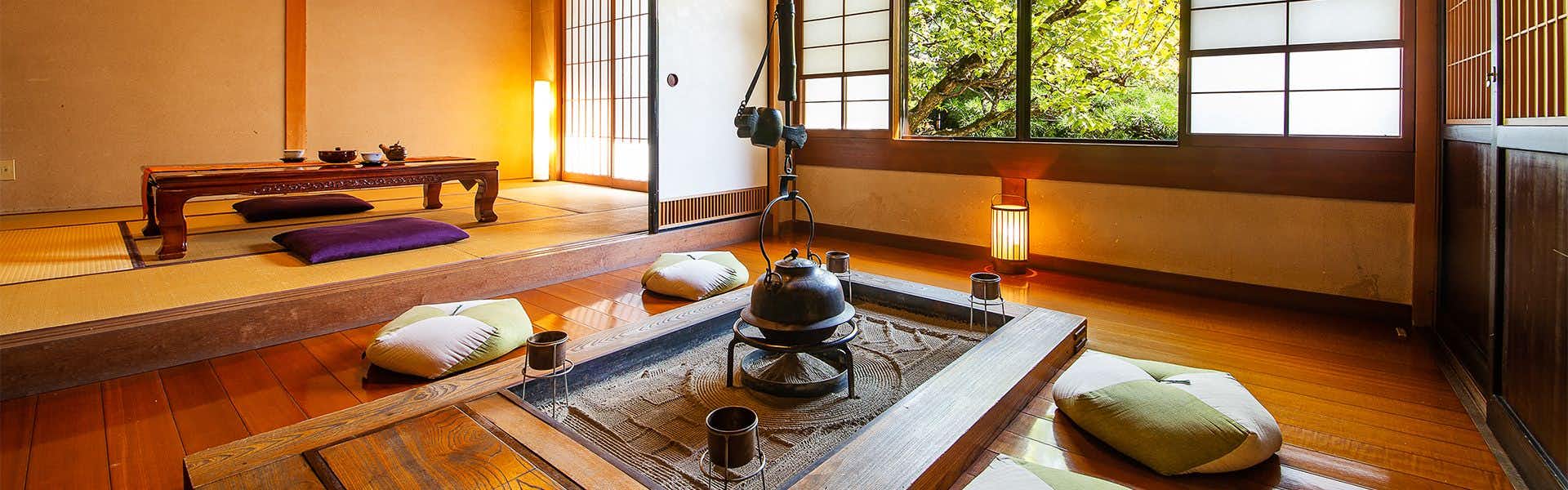 Ryotei Ryokan Yasui sunken hearth room with floor cushions and a tatami alcove