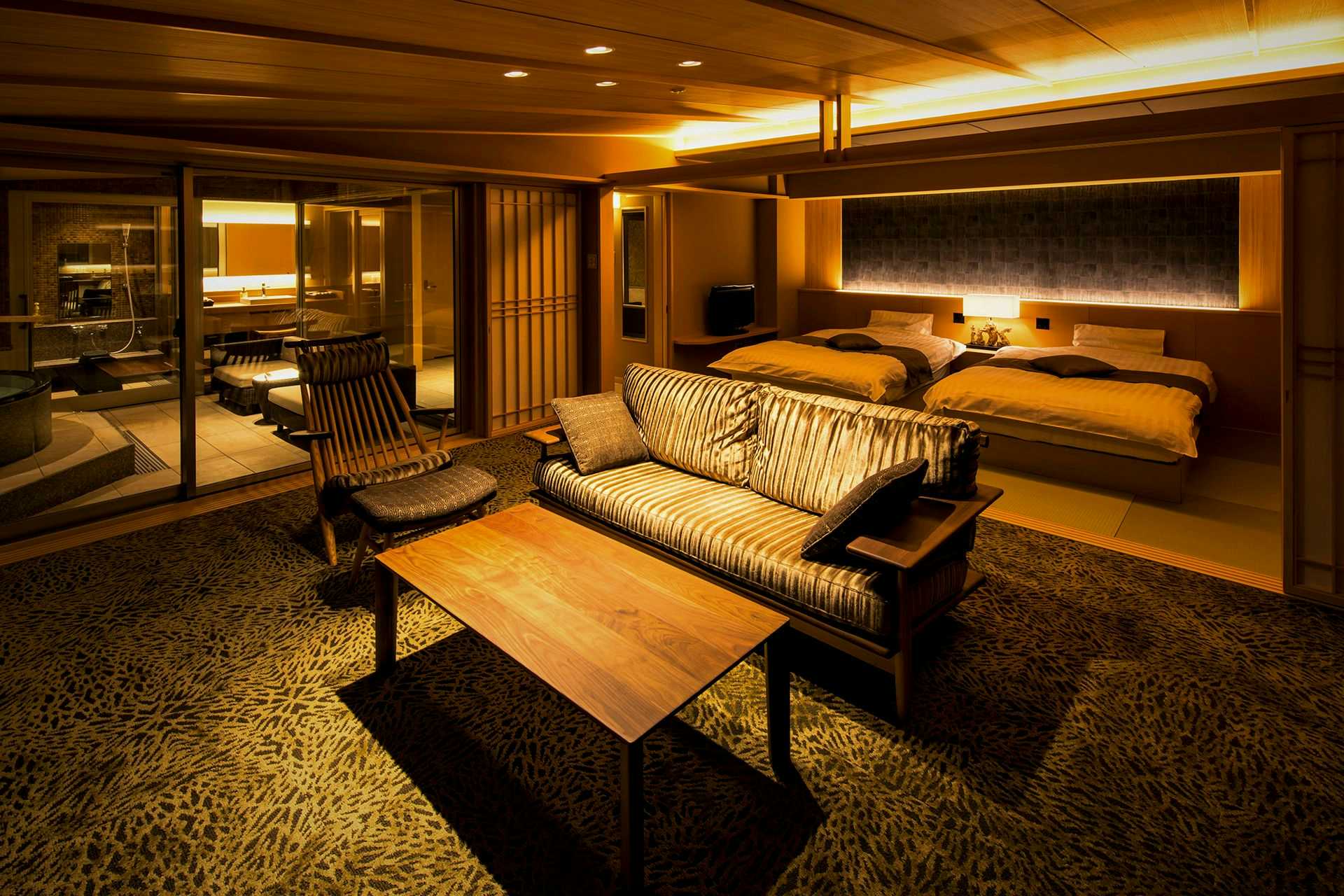 Inatoriso with this scene, where its dark-toned guest room combines a lounge, low table and bed alcove.