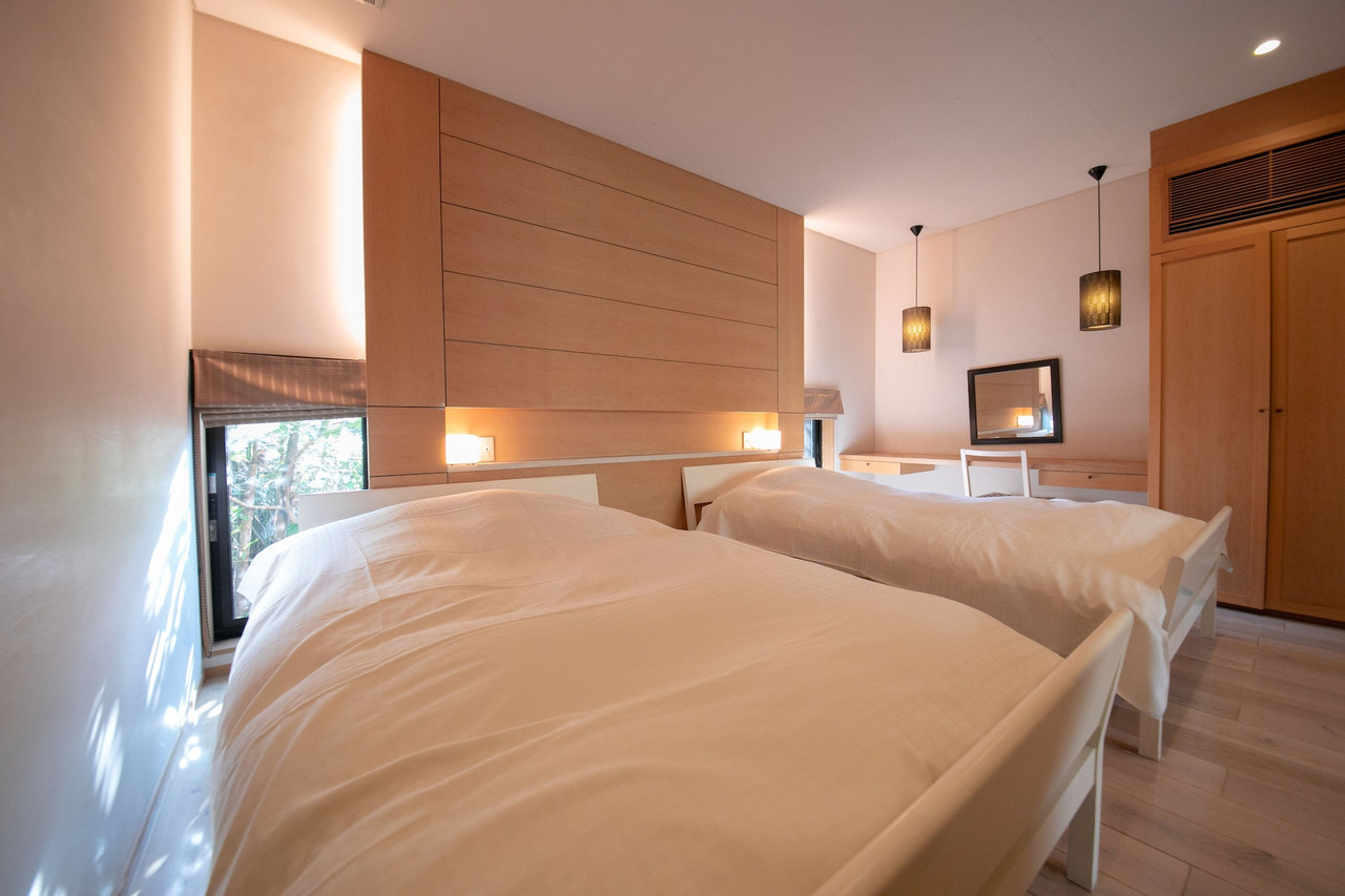 A bedroom with twin beds and wood-paneled walls.