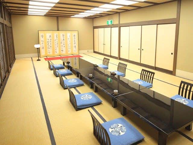 Ryoutei Ryokan Oarai Yamaguchirou with a long banquet room lined with low black tables.
