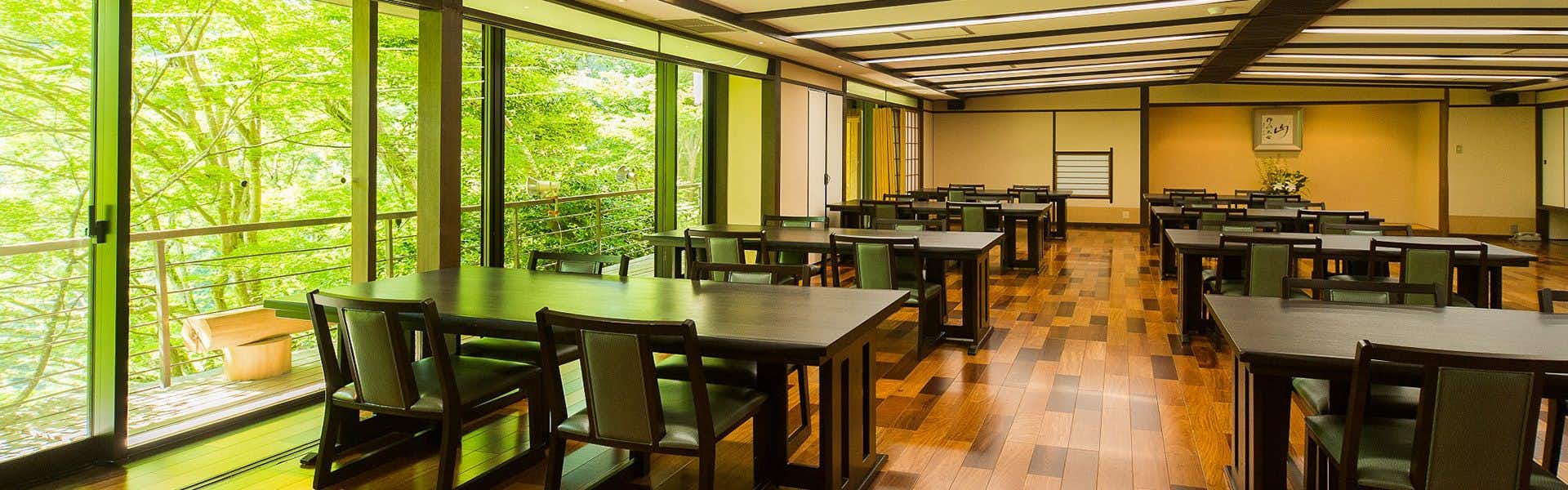 Momijiya Main Building with a forest dining room lined with broad windows.
