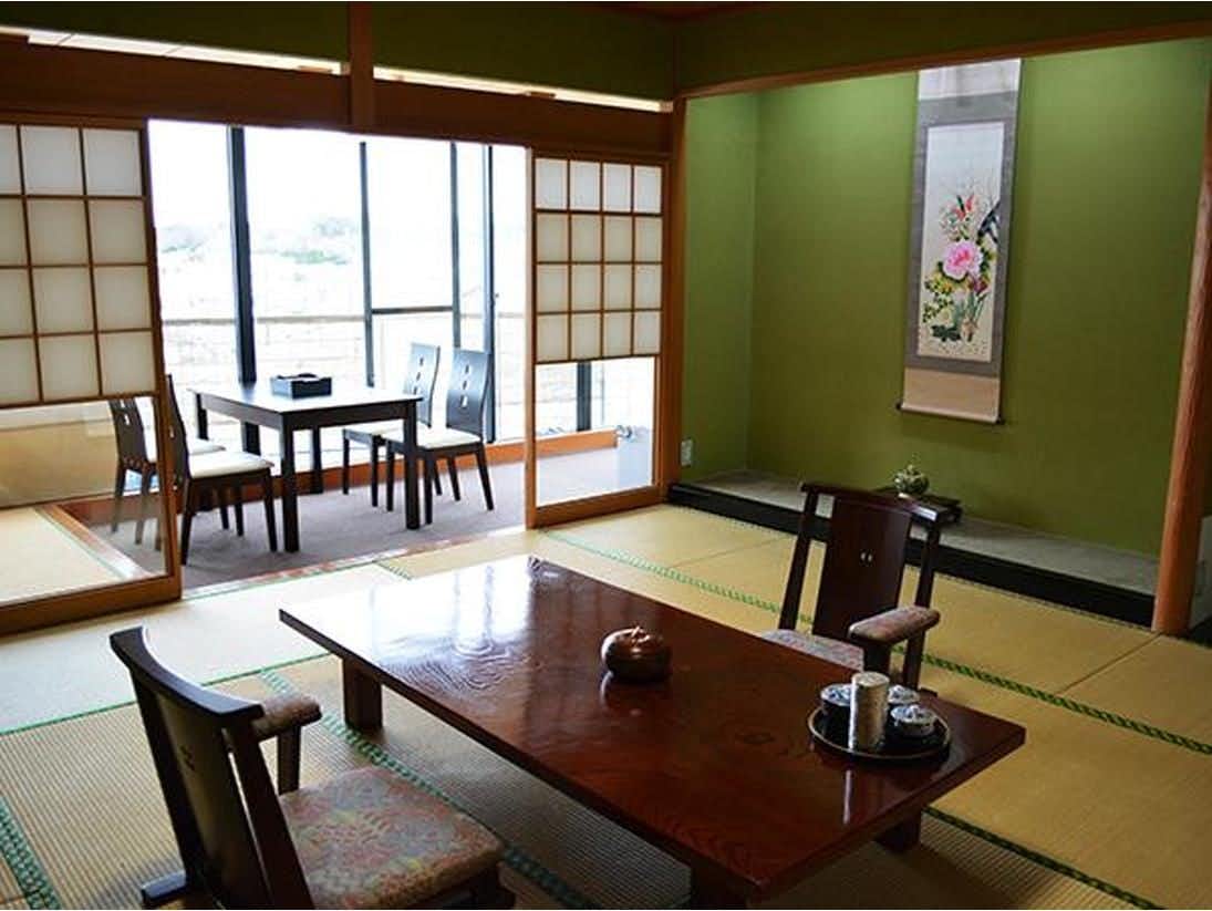 Hareya Ryokan with a tatami guest room with low table and ocean-facing windows.