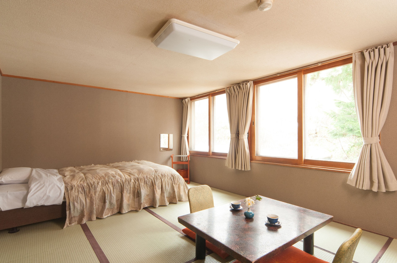 A bright room combines beds with a broad window.