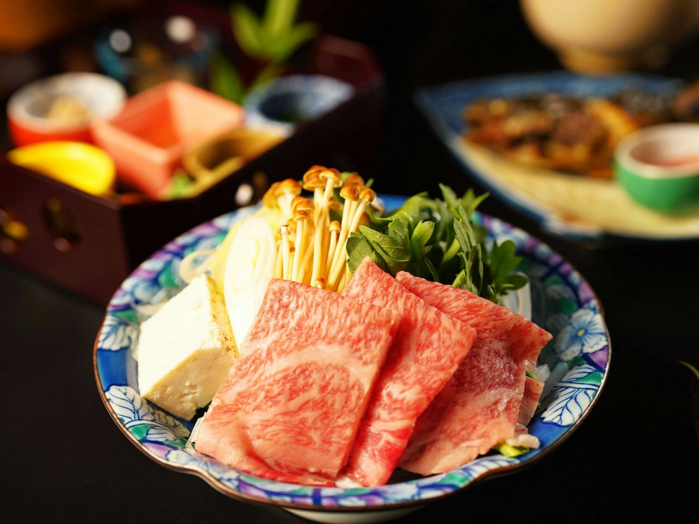 Sakae no Yu Ryokan with marbled beef slices arranged with tofu and vegetables.