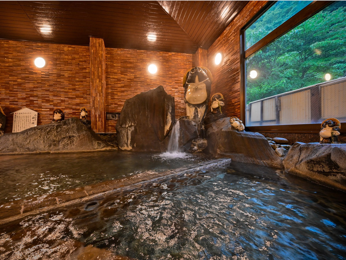 Stone bath beneath a wooden roof.