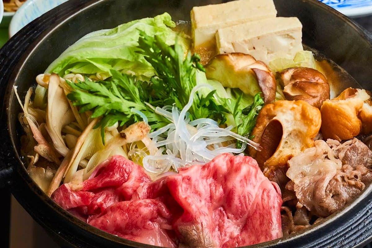 Nakaya Annex Fudokaku with marbled beef and vegetables simmering in a black iron pot.