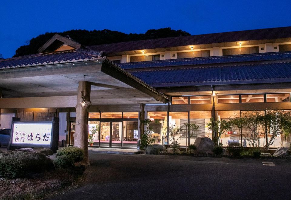 A traditional property is softly illuminated against the evening sky.