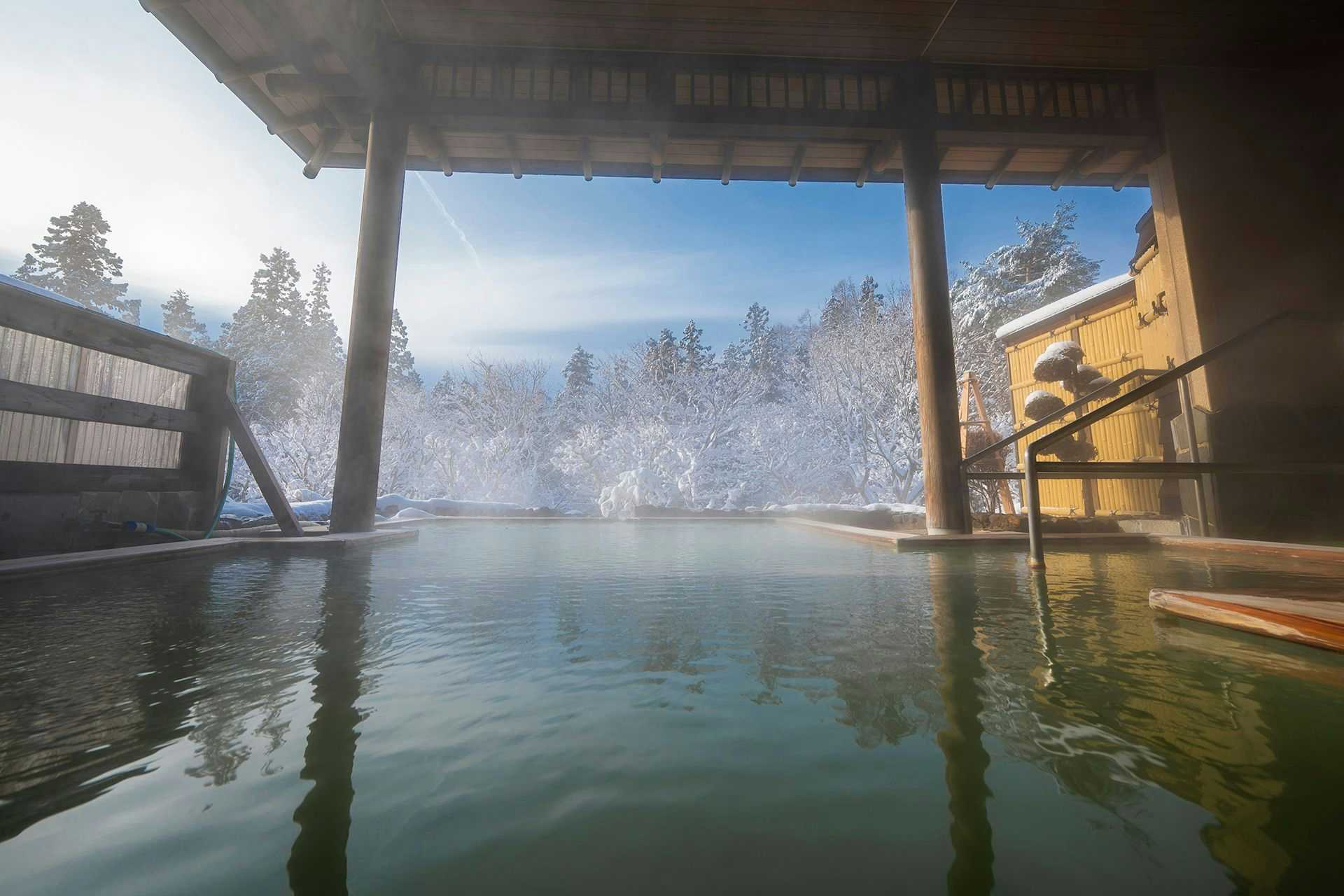 Seifutei with an open-air stone bath surrounded by deep winter snow.