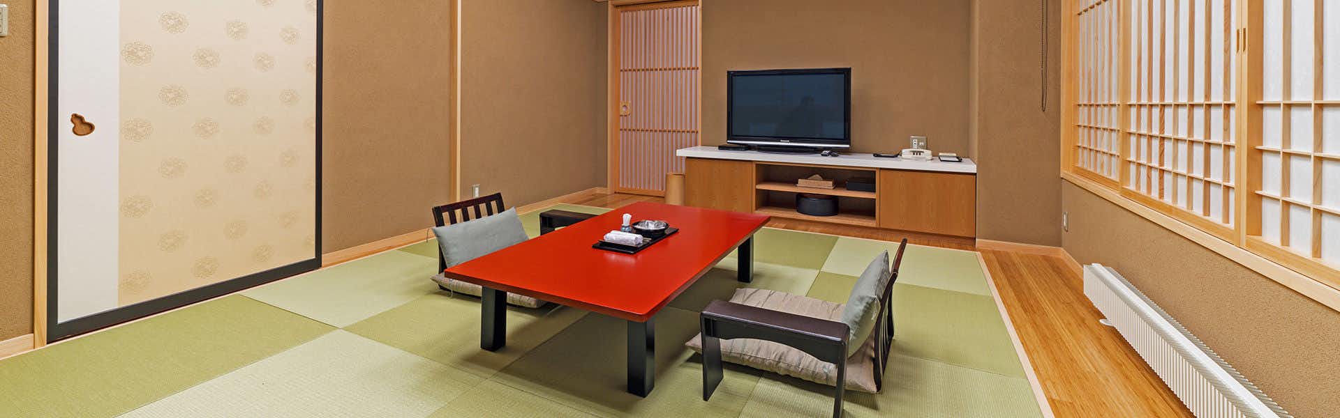 Akayu Onsen Uesugi no Miyu Gotenmori with a tatami guest room with red low table and television.
